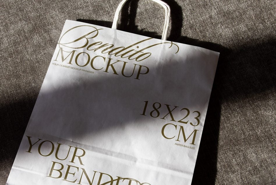 Flat lay of canvas tote on textured fabric with dramatic angled natural lighting