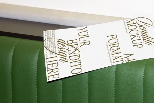 Elegant flyer mockup on green leather surface presenting design space, ideal for showcasing graphic designs in a realistic setting for designers.