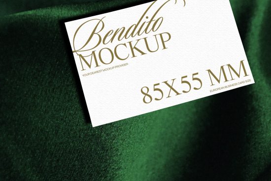 Elegant business card mockup on green fabric showcasing gold typography design, ideal for designers presentations 85x55mm European standard size.