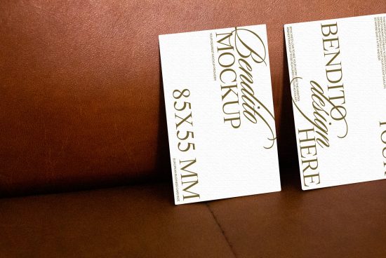 Elegant business card mockup on a brown leather surface, showcasing design space and typography, perfect for branding presentations.
