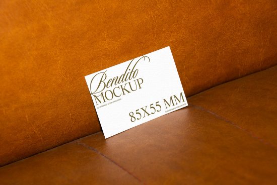 Elegant business card mockup on brown leather couch, showcasing script font and European card size for designers, perfect for presentations and portfolios.