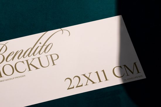 Elegant envelope mockup lying on a dark teal surface showcasing gold foil stamping, 22x11 cm size indication for designers.