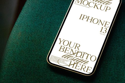 Smartphone Mockup showcasing iPhone 13 on green fabric suitable for digital design presentations, mobile app interface, and graphic display.