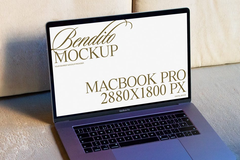 MacBook Pro on cream cushions with natural window light casting shadows