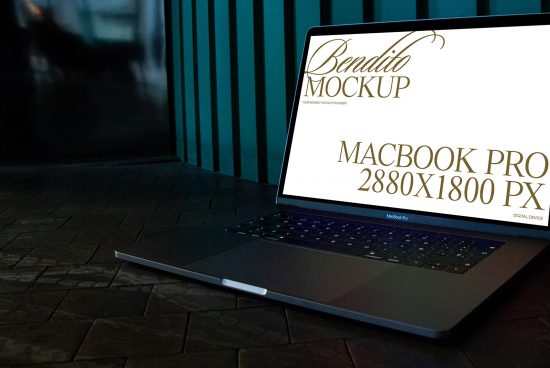 MacBook Pro on dark brick surface with screen showing high-resolution mockup template, ideal for digital design presentations.