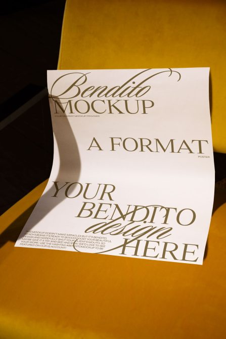 Poster mockup draped over mustard yellow sheet with natural fold shadows