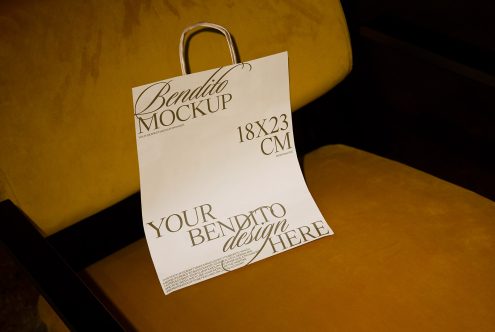 Paper bag mockup on a mustard color sofa showcasing customizable design space, ideal for branding presentations and packaging graphics.