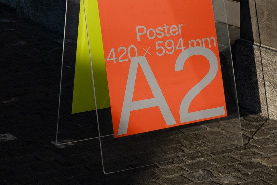A2 size poster mockup on sidewalk displaying vibrant colors and clear typography, ideal for designers to showcase advertising designs.