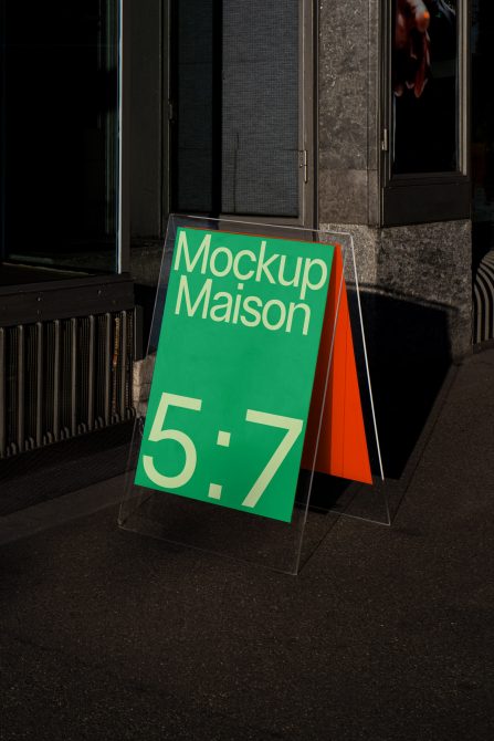 Urban street mockup of a freestanding advertising A-frame sign with a bold green and orange design, perfect for presenting branding graphics and fonts.