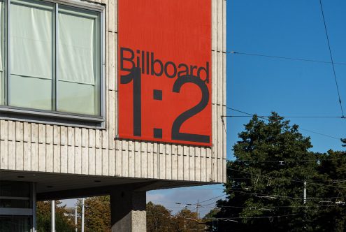 Urban billboard mockup on the side of a building with clear sky, ideal for realistic advertising designs and cityscape presentations.