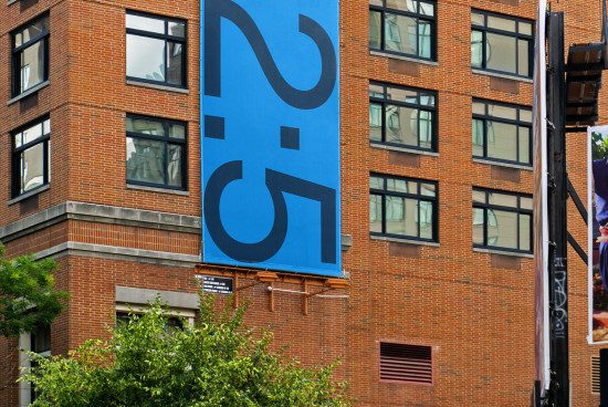 Urban building with a large blue graphic design banner, showcasing modern font typography for design inspiration.