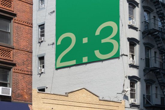 Outdoor billboard mockup on a building facade with a large green banner displaying the ratio 2:3, ideal for showcasing advertising designs.