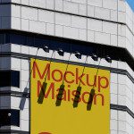 Urban building mockup example with bold yellow sign for outdoor advertising and design showcase, clear sky, modern cityscape.