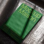 Green book mockup on bubble wrap, realistic hardcover book design template for presentation, publishing display, 235x312mm.