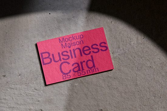 Pink business card mockup on concrete showing shadows, ideal for design presentations in the graphic, mockup, and template categories.