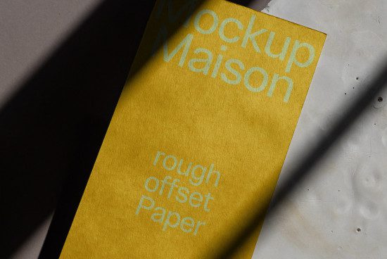 Yellow paper texture mockup with typographic design in sunlight and shadow, ideal for presentations, graphic design assets.