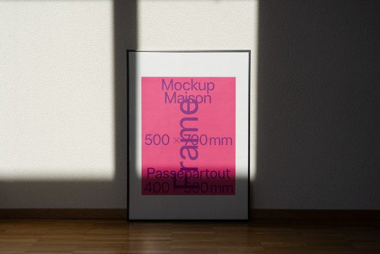 Modern poster frame mockup standing on wooden floor against white wall with shadows, realistic template for designers.
