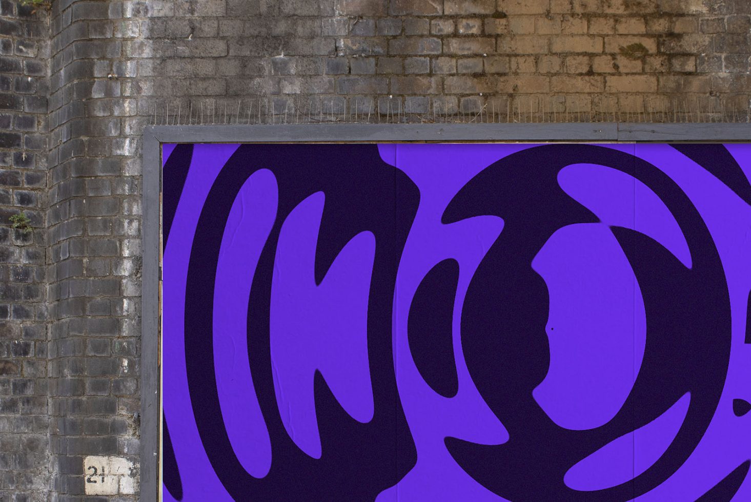 Abstract purple graphics billboard mockup on urban brick wall, ideal for outdoor advertising designs, modern urban templates.