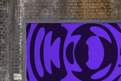 Abstract purple graphics billboard mockup on urban brick wall, ideal for outdoor advertising designs, modern urban templates.