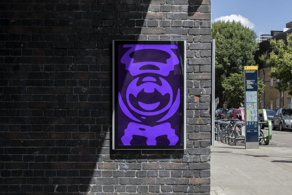 Outdoor poster showing playful purple character illustration on brick wall