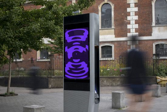 Digital kiosk mockup displaying purple abstract graphics in an urban setting, with blurred pedestrian movement. Perfect for designers' advertising mockups.