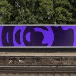 Outdoor billboard mockup with abstract purple graphics displayed at a train station, ideal for showcasing advertising designs.