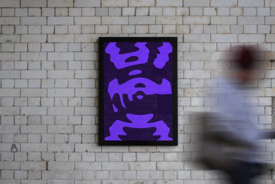Modern abstract poster design mockup with dynamic purple shapes on dark background, displayed on a white brick wall, blurred person walking by.