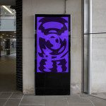Digital signage mockup in urban setting showcasing vibrant abstract graphic design, ideal for designers' presentations and portfolios.
