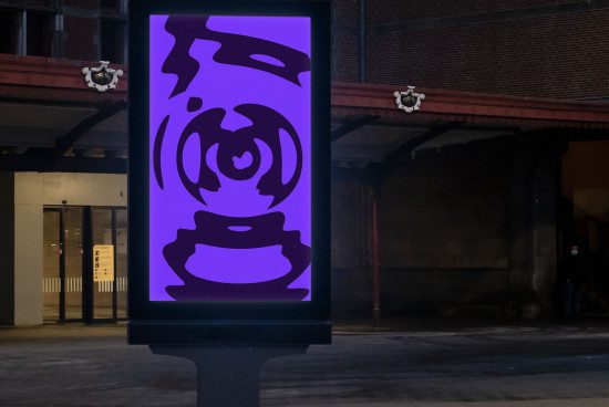 Urban billboard mockup displaying purple abstract artwork at night, ideal for showcasing advertising designs in a realistic environment.