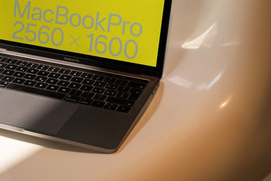 Laptop screen mockup displaying resolution details in bright yellow, ideal for showcasing digital design work to clients on a designer marketplace.