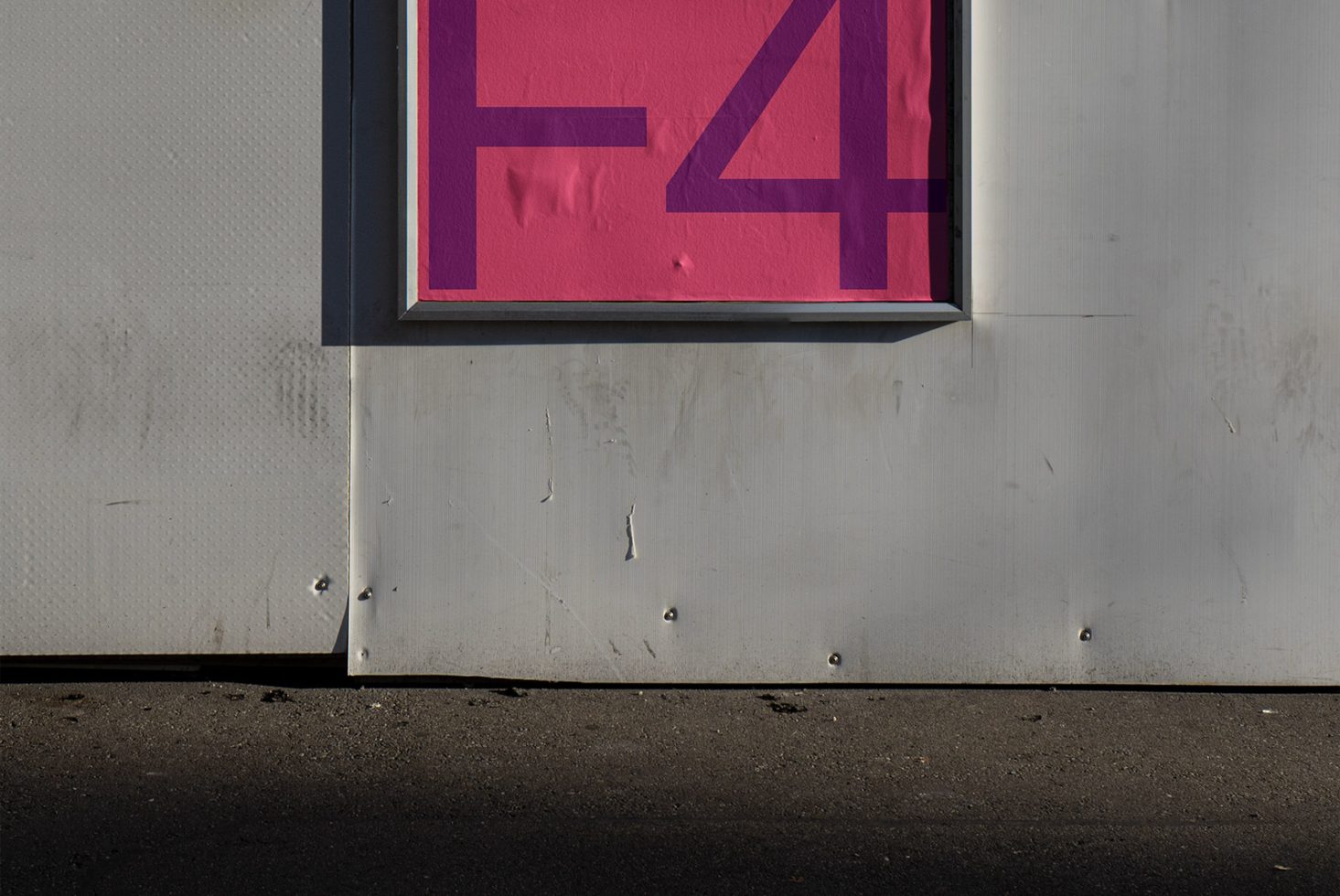 Urban sign mockup with lettering in a modern, bold font, showcasing shadows and textures, ideal for presenting designs or branding elements.