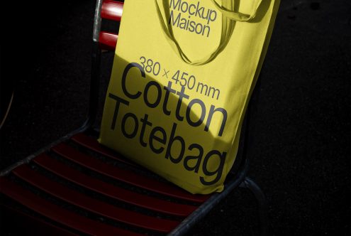 Yellow cotton tote bag mockup laid on red chair, realistic detail for print design presentation, branding, packaging, advertising.