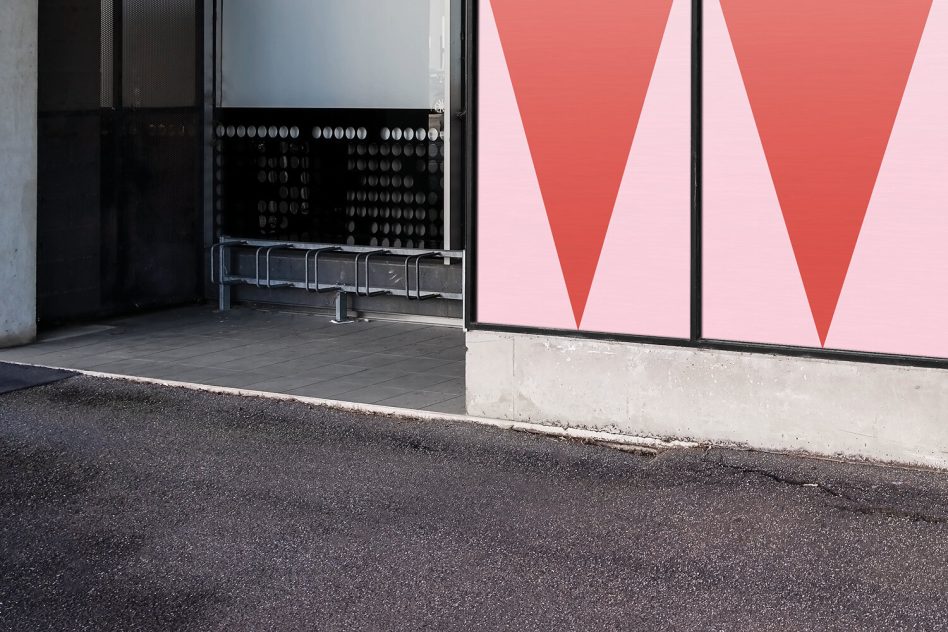 Two large framed displays showing coral pink gradient triangle shapes in storefront