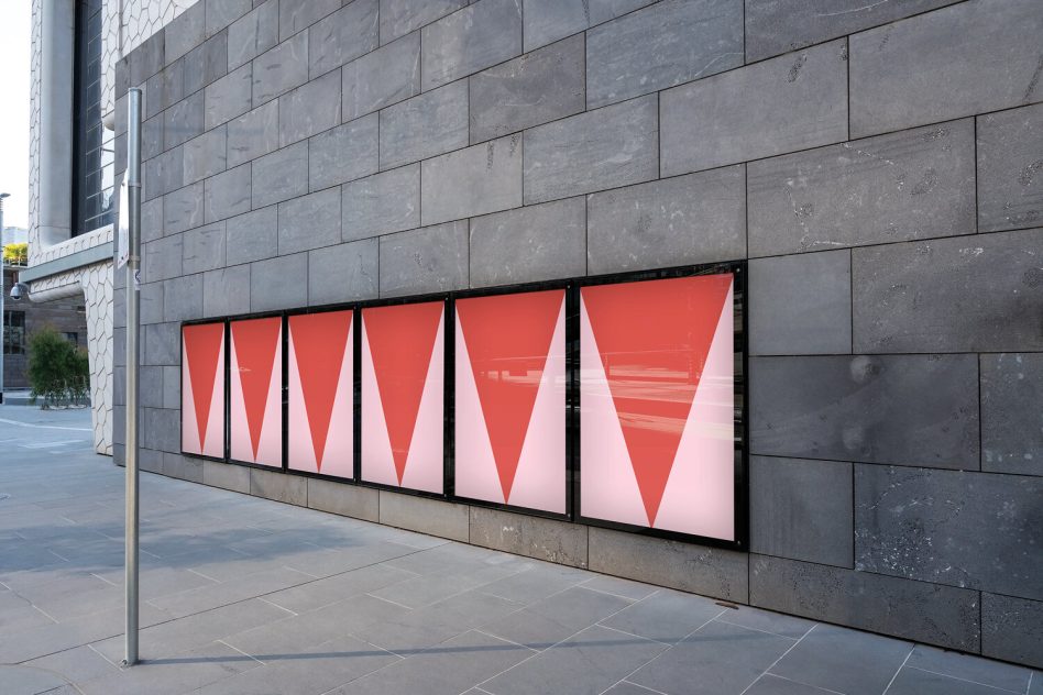 Urban poster mockup on a wall with modern architecture, showcasing geometric design posters with red gradients, ideal for presentations.