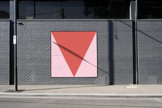 Minimal geometric graphic poster mockup on an outdoor brick wall, clear sky, urban design template for display.