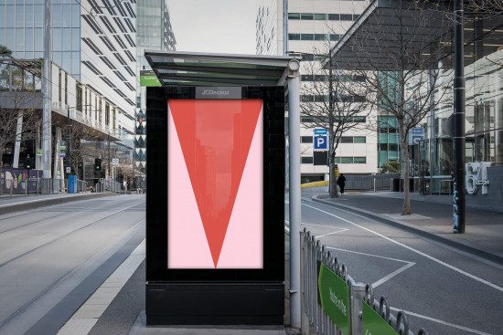Urban billboard mockup with a red and pink design poster in a street setting, surrounded by modern architecture, ideal for advertising and graphic display.