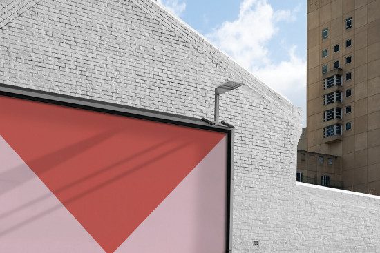 Billboard mockup on urban building wall for outdoor advertising and design showcase, clear sky, editable graphic design template.
