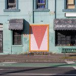 Urban cafe exterior with geometric mockup poster, weathered architecture, vintage signage for design templates.