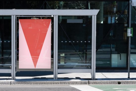 Bus stop advertising mockup with a large red downward arrow graphic in an urban setting, perfect for outdoor advertising design presentation.