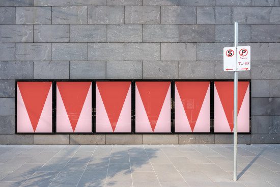 Urban billboard mockup series with red geometric design against a stone wall, for outdoor advertising and poster presentations.