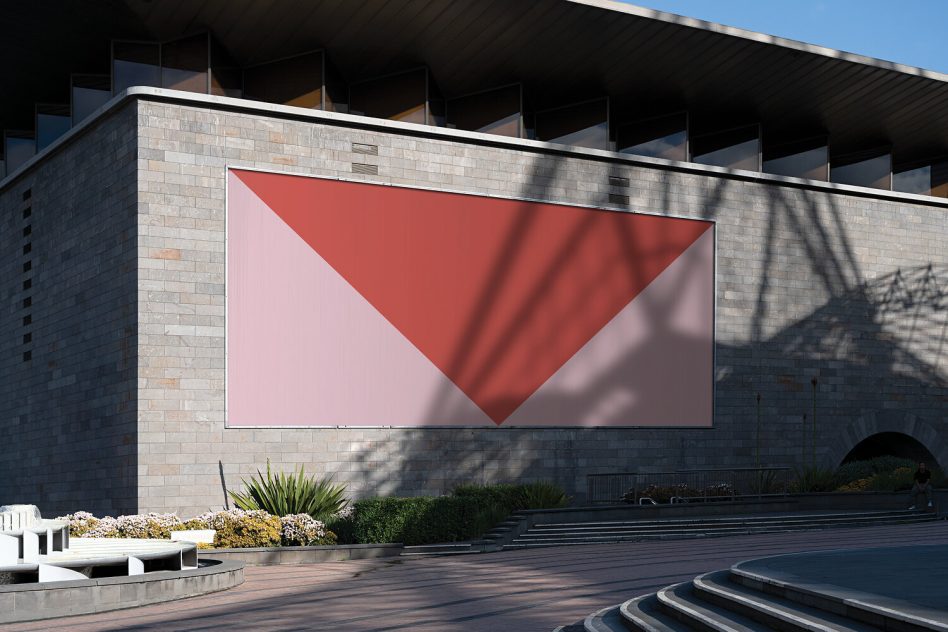 Wide horizontal billboard mockup with inverted coral triangle on minimalist stone building