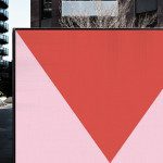 Urban billboard mockup with red triangular graphic for outdoor advertising in modern cityscape, designers' mockup template.
