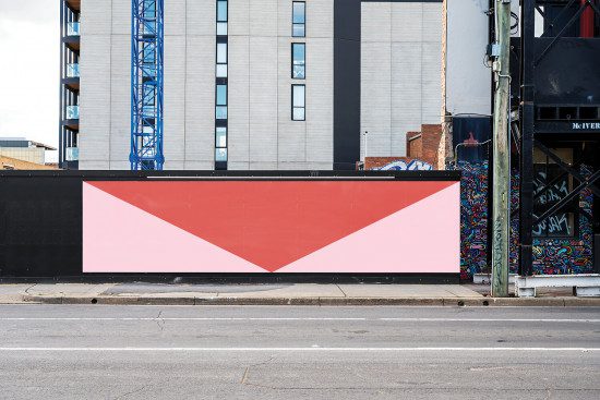 Urban billboard mockup with a red and pink envelope design on a street backdrop, perfect for advertising presentation.