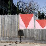 Urban street art mockup with geometric red triangles on weathered wooden fence, ideal for showcasing graffiti or outdoor advertising designs.