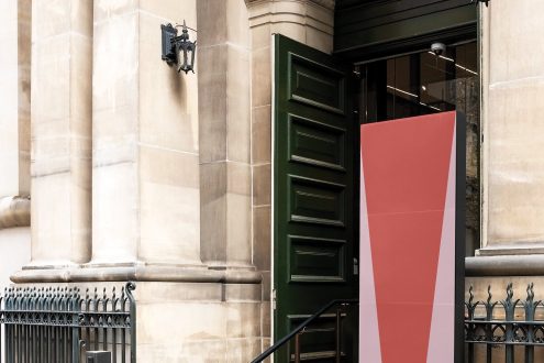 Elegant outdoor signage mockup on building facade with classical architecture, ideal for presenting logos and branding designs for designers.