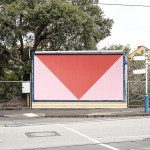Empty urban billboard mockup on a roadside with a red background and a white downward arrow, ready for advertising graphic design.
