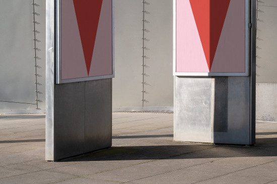 Outdoor billboard mockup with minimalist red and pink triangle design in an urban setting, ideal for presenting advertising graphics.
