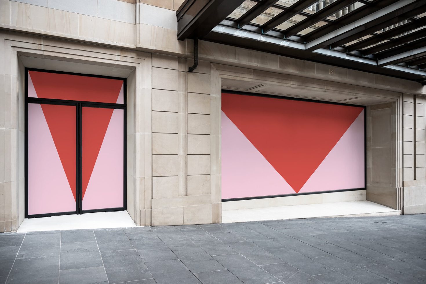 Outdoor advertising mockup featuring storefront with large window graphic display, stone facade, and urban setting for designers.