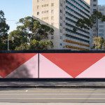 Urban scene with a vibrant red and pink graphic wall design, street view, modern cityscape, architecture backgrounds, shadow patterns.