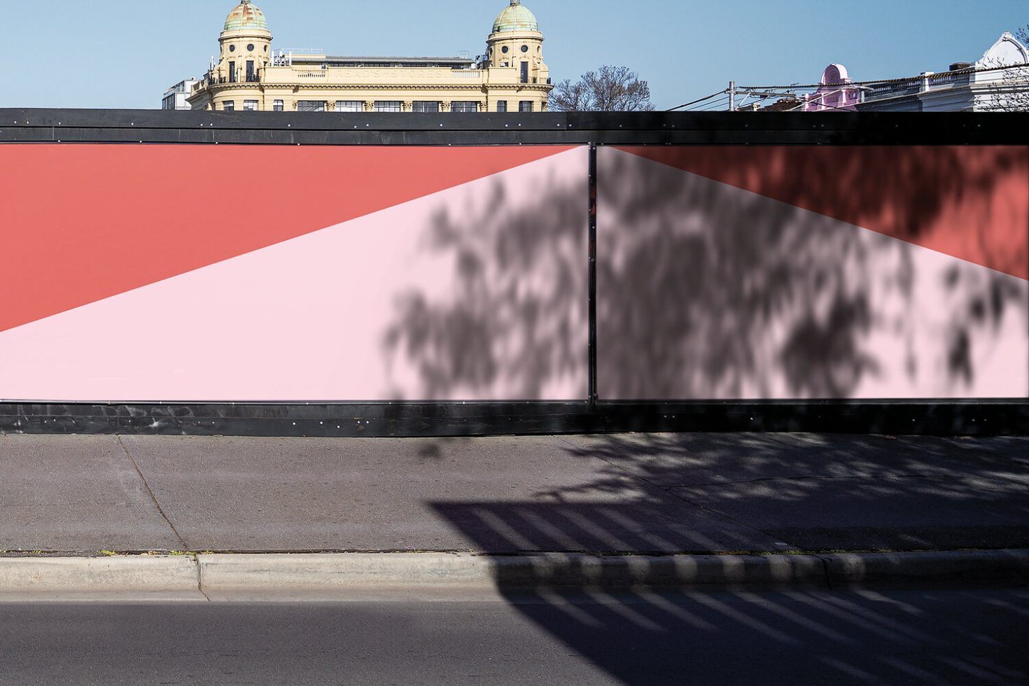 Urban billboard mockup with vivid colors and tree shadow overlay against historic building backdrop, ideal for designers' presentations.